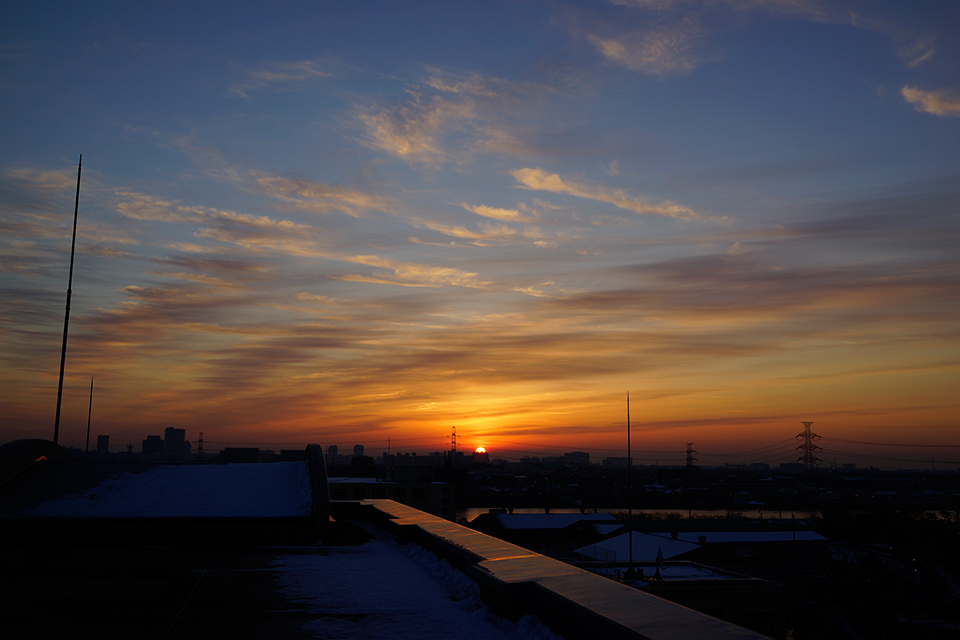 雪と放射状の筋雲と青空の日の出